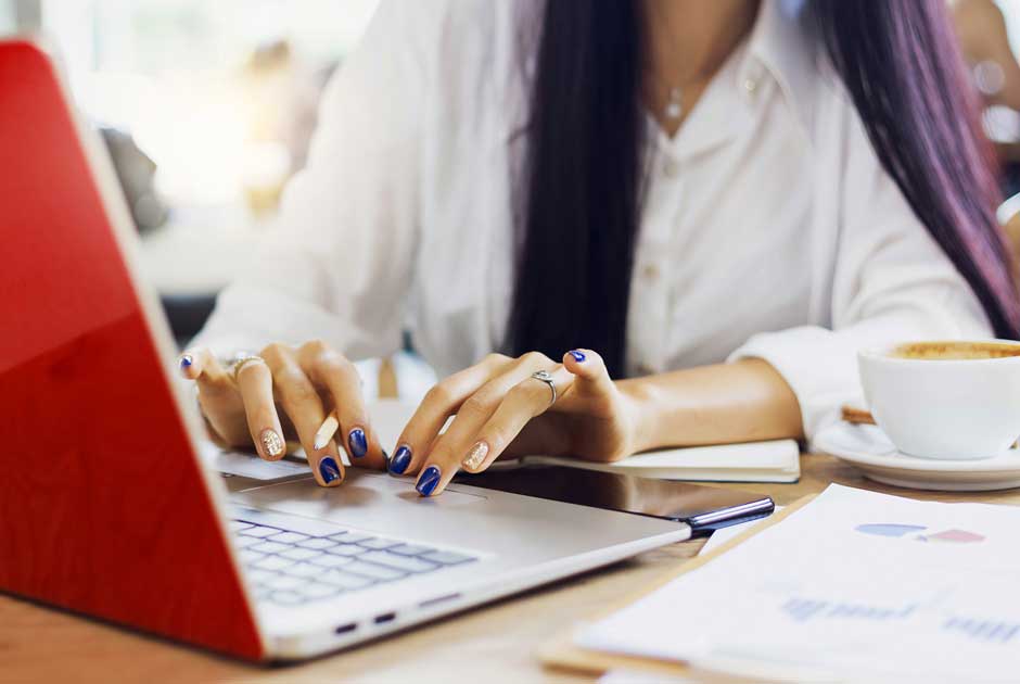A woman types busily at a computer with a red screen